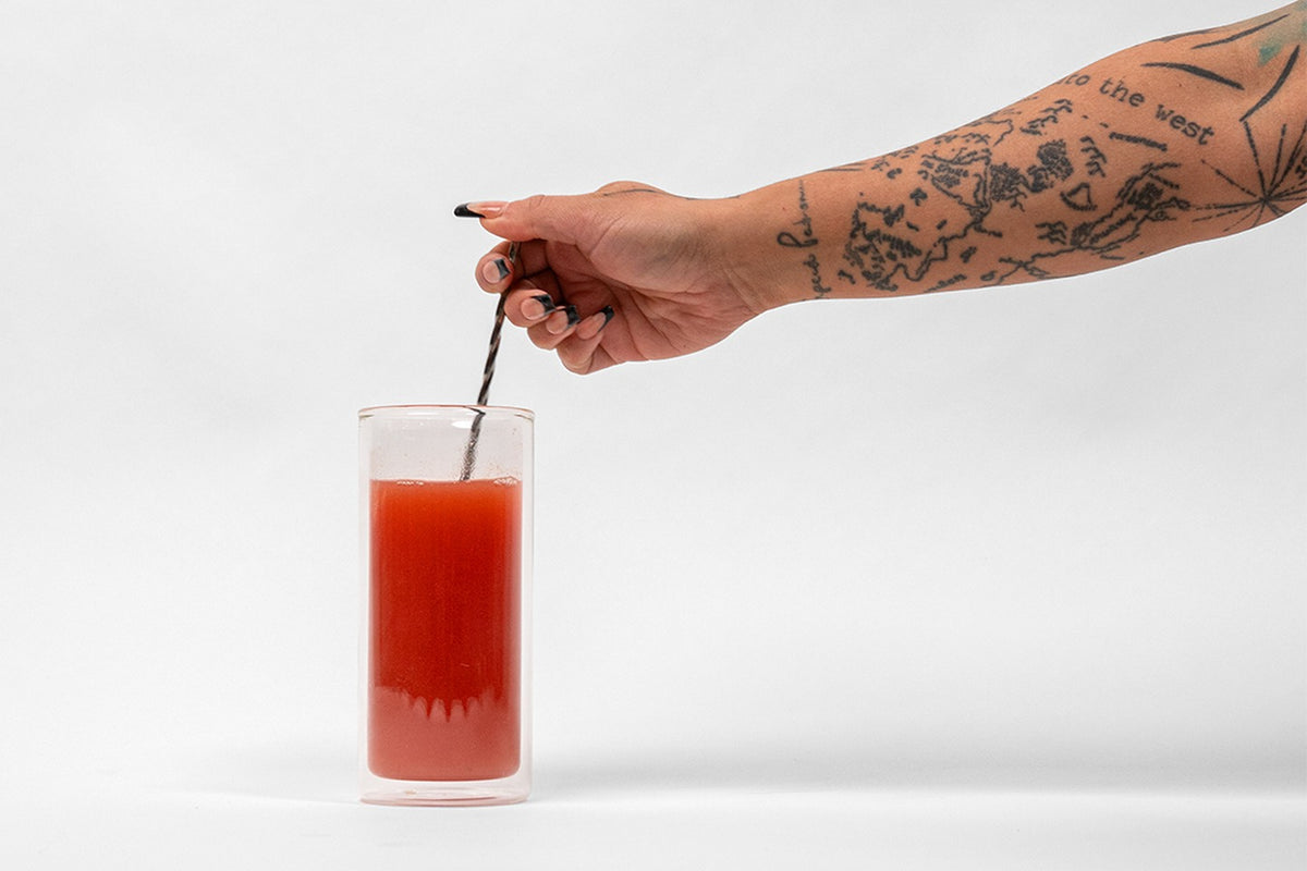 Stirring a scoop of NEWBRAIN into a glass of cold water